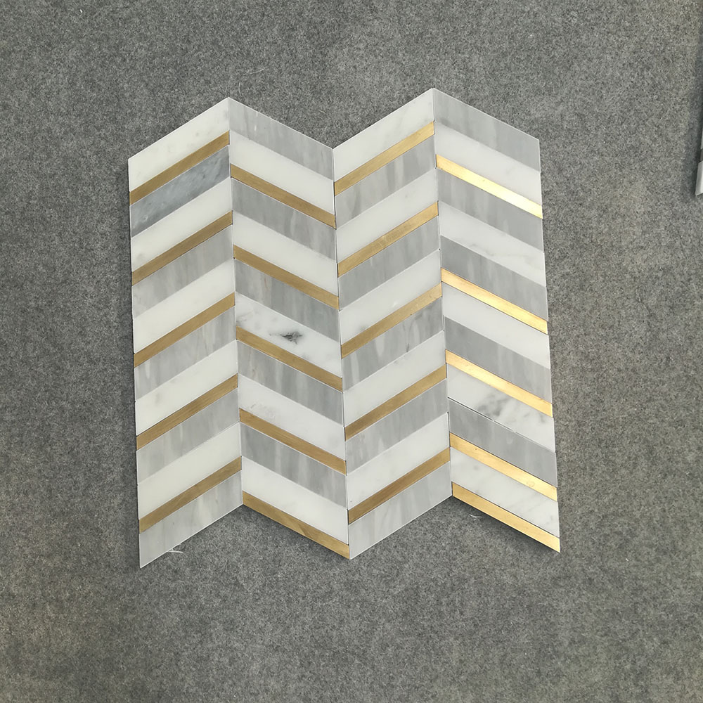 Light grey and white marble with brass mosaic tile 