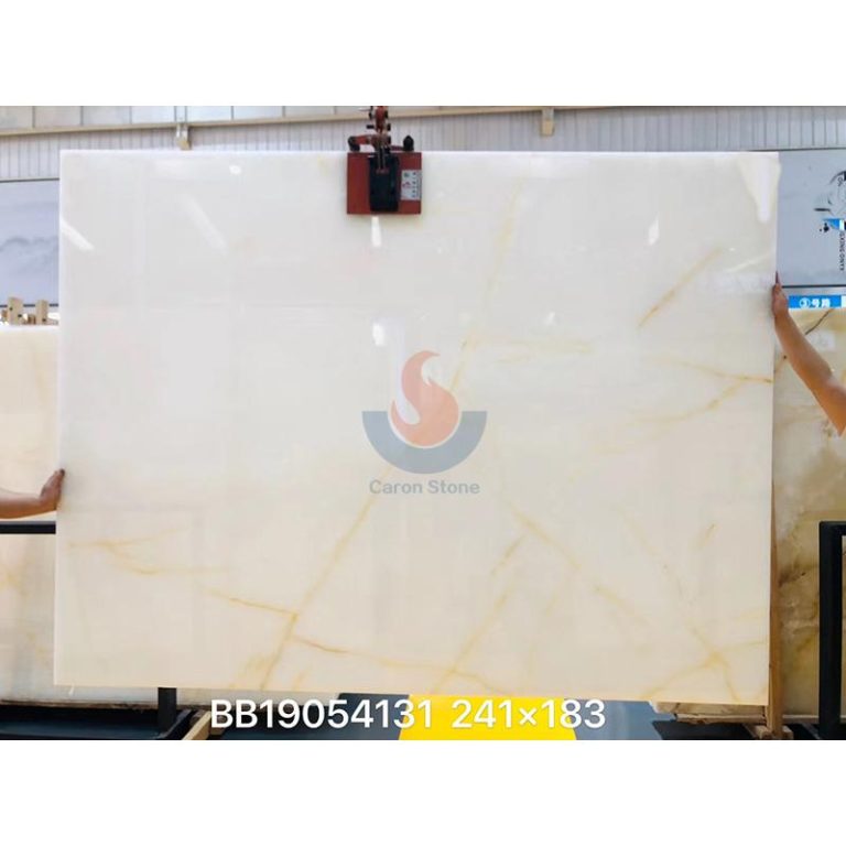 Full jumbo slab of polished White Onyx featuring pristine snow-white background and subtle gold veins by Caron Stone.
