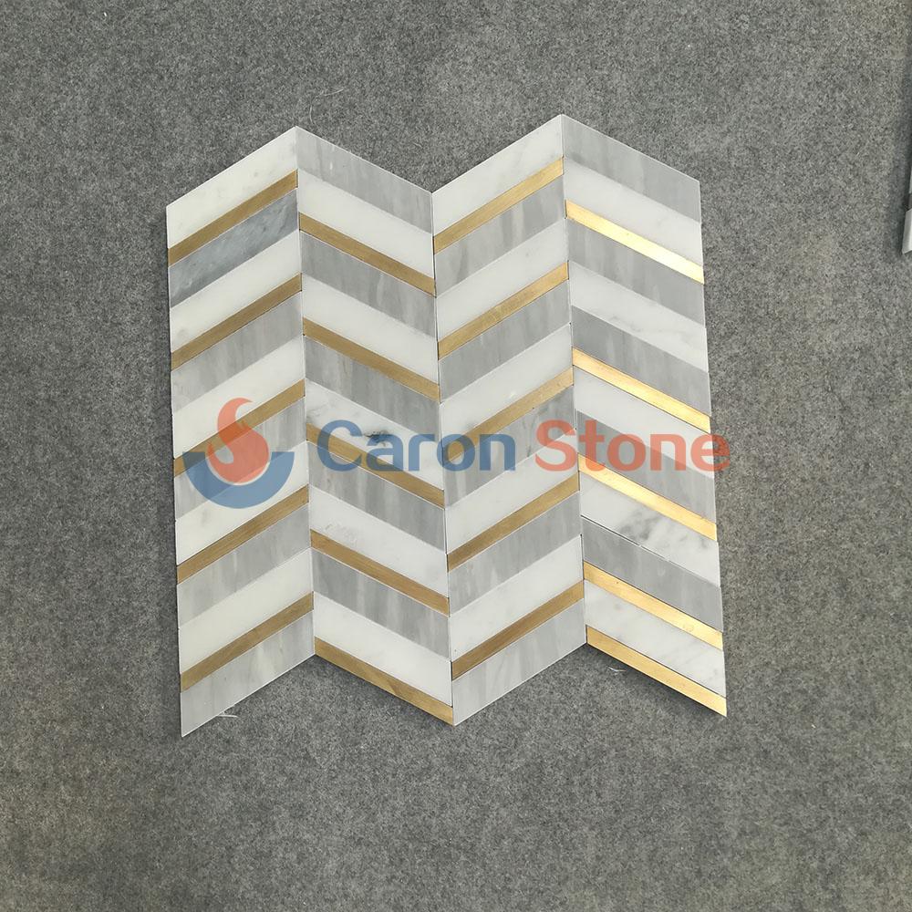 Light grey and white marble with brass mosaic tile