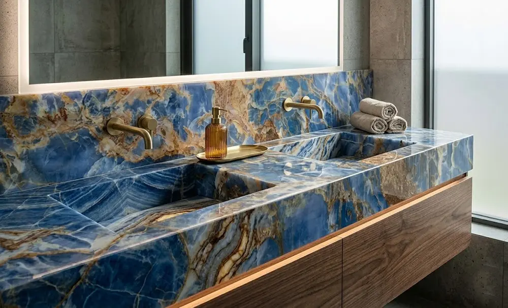 Bespoke Blue Onyx Bathroom Vanity Design Elegant master bathroom vanity top made from polished Blue Onyx with modern brass hardware.