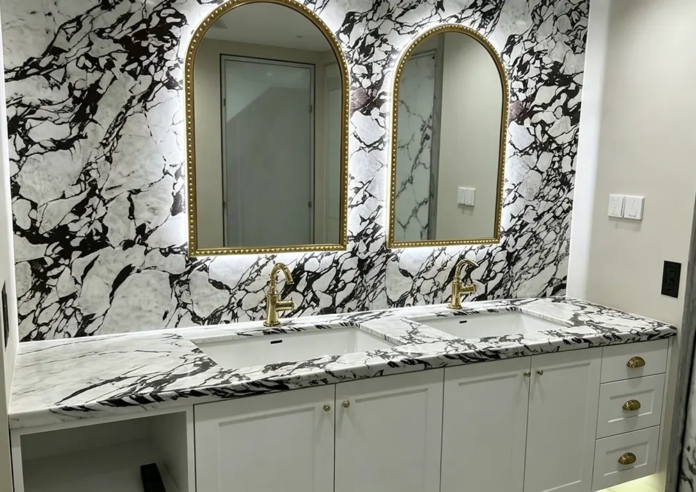 Grand Double Vanity in Calacatta Viola A wide luxury master bathroom featuring a long Calacatta Viola double vanity with two undermount sinks and a massive continuous marble backsplash.