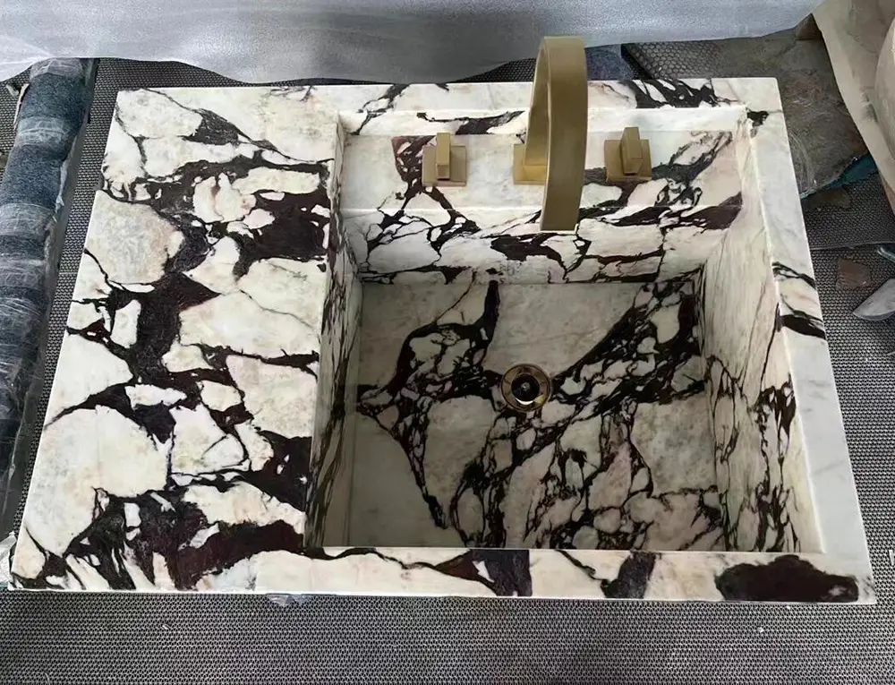 Styling Calacatta Viola with Brass Hardware Detail shot of unlacquered brass faucet hardware mounted elegantly on a deeply veined Calacatta Viola marble sink top.