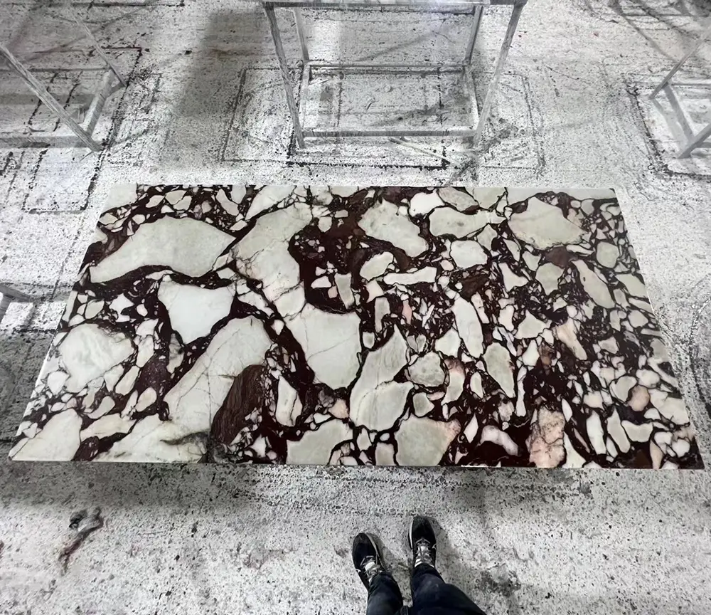 Premium Calacatta Viola Marble Slab Selection A premium jumbo slab of Italy Calacatta Viola marble featuring intense dark grey and burgundy brecciated veins in the Caron Stone factory.