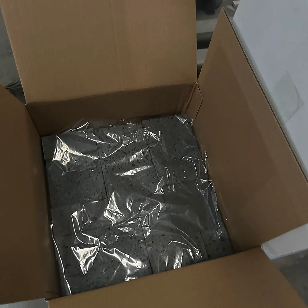 export-packaging-volcanic-rock-wall-tiles-caron-stone Boxes of 3D volcanic rock mosaic panels stacked securely on reinforced wooden pallets, shrink-wrapped for international sea freight export.