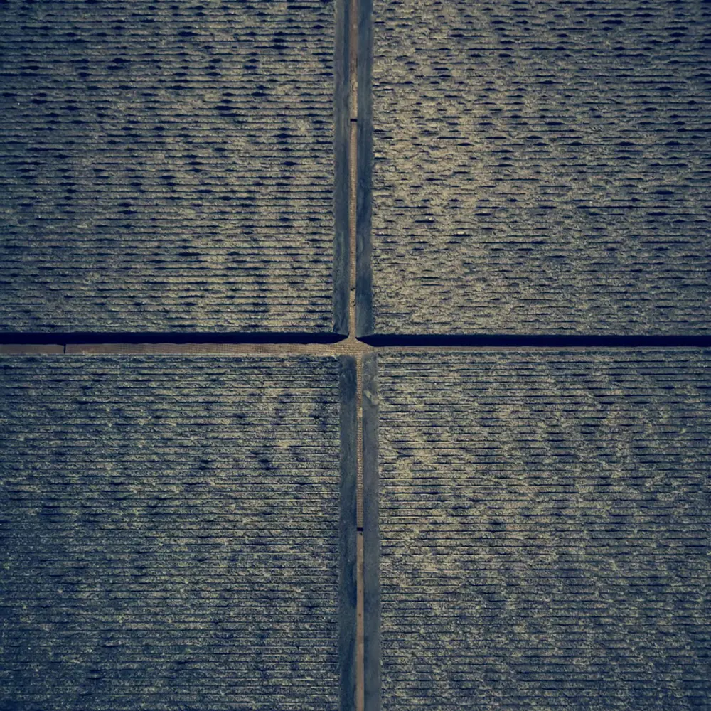 Seamless Fluted Stone Corner Fabrication Macro detail of two fluted stone panels meeting at a perfect 45-degree mitered corner, wrapping the grooved texture seamlessly around a column.
