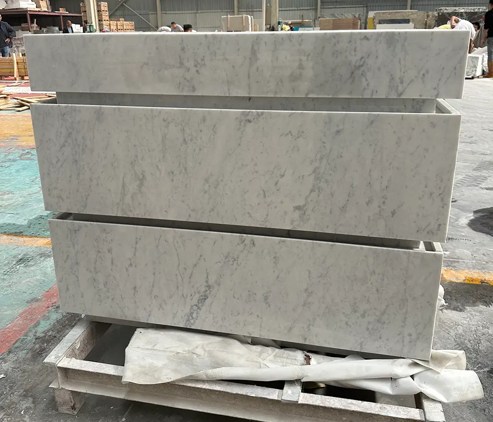 full-height-vein-matched-carrara-drawers-caron-stone Macro view of stacked vanity drawer fronts illustrating continuous vein-matching of the grey Carrara marble patterns crossing the drawer gaps.