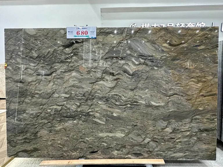 High-definition front view of an 18mm thick Fusion Quartzite slab displayed in a showroom. The stone surface exhibits an intense wavy, folded bedding structure, interweaving various shades of grey, brown, earth tones, and subtle metallic hues. The high-gloss polished finish clearly reflects overhead showroom lighting. A price tag reading "680 yuan/m²" is attached to the top edge of the slab, which rests on wooden supports on the floor along the bottom edge.