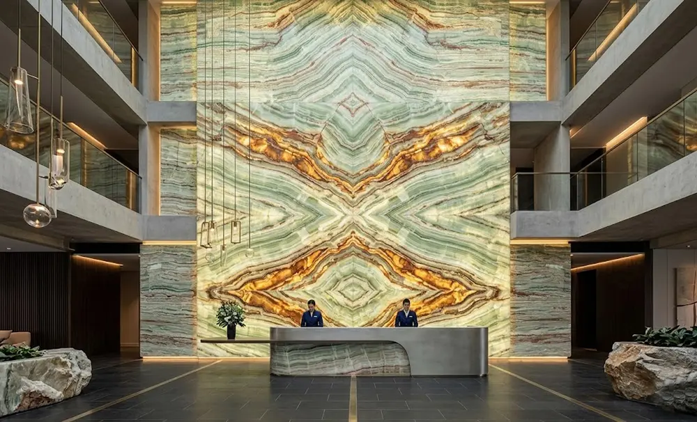Backlit Green Onyx Wall Cladding Masterpiece A monumental floor-to-ceiling backlit Green Onyx feature wall in a luxury hotel reception area.