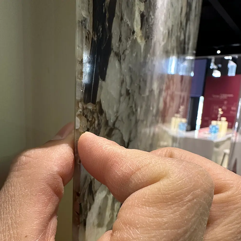 Translucent Composite Backing Technology Macro side-profile view of an ultra-thin stone panel, showing the 2mm Patagonia Quartzite veneer bonded to the high-clarity translucent fiberglass backing.